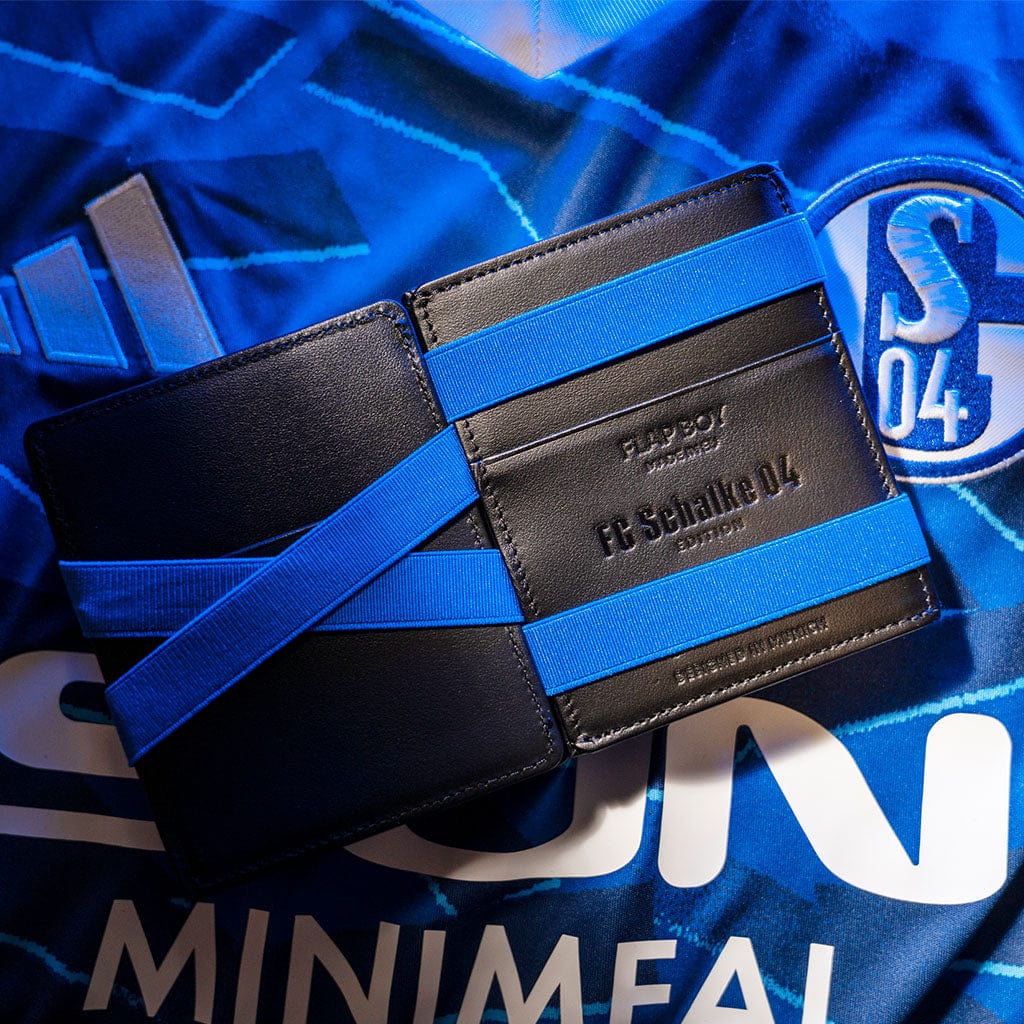 fc schalke 04 edition jaimie jacobs gedlbeutel flap liegt  aufgeklappt auf schalke trikot 2025